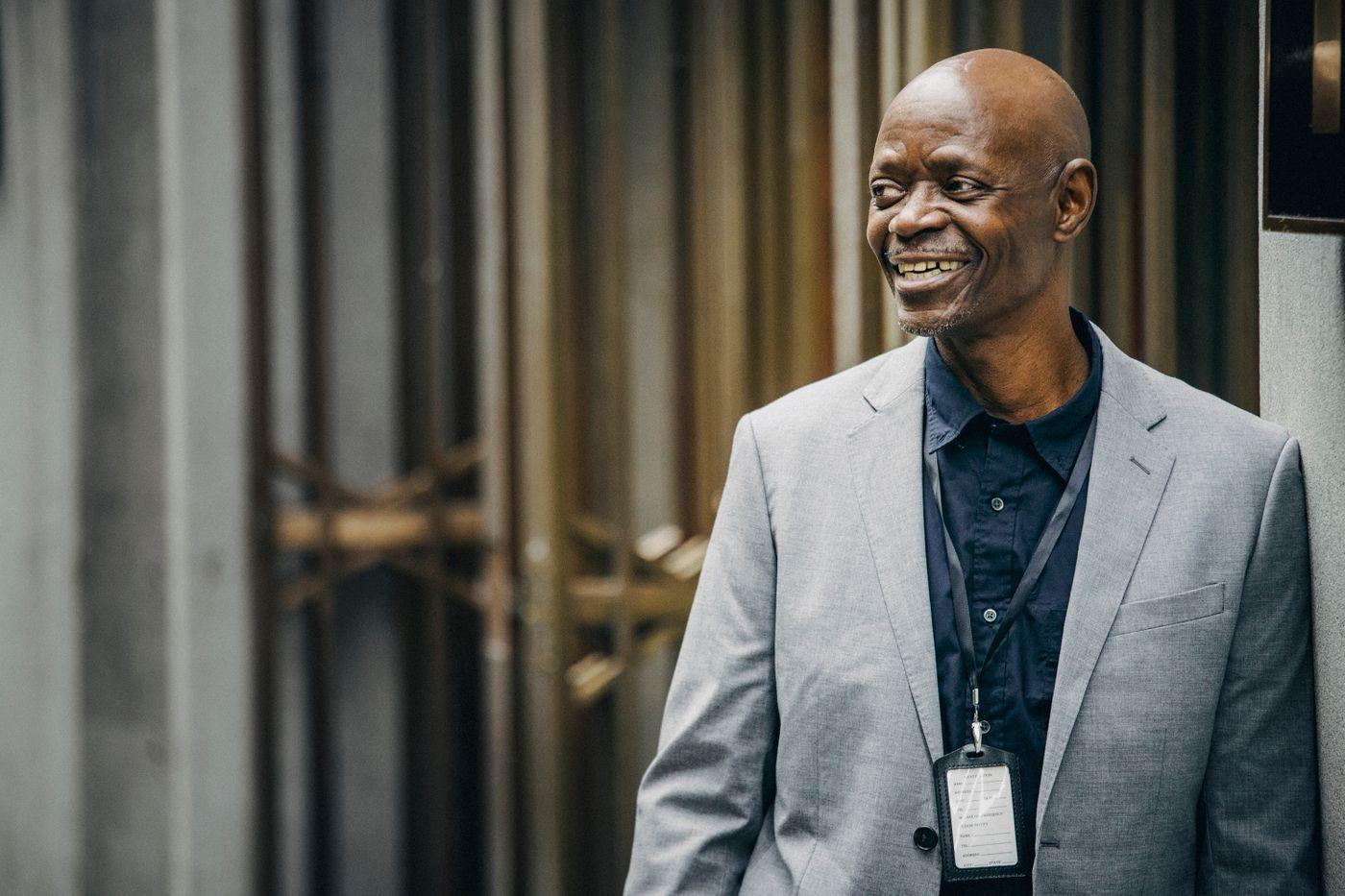Black business leader smiling outside an office building