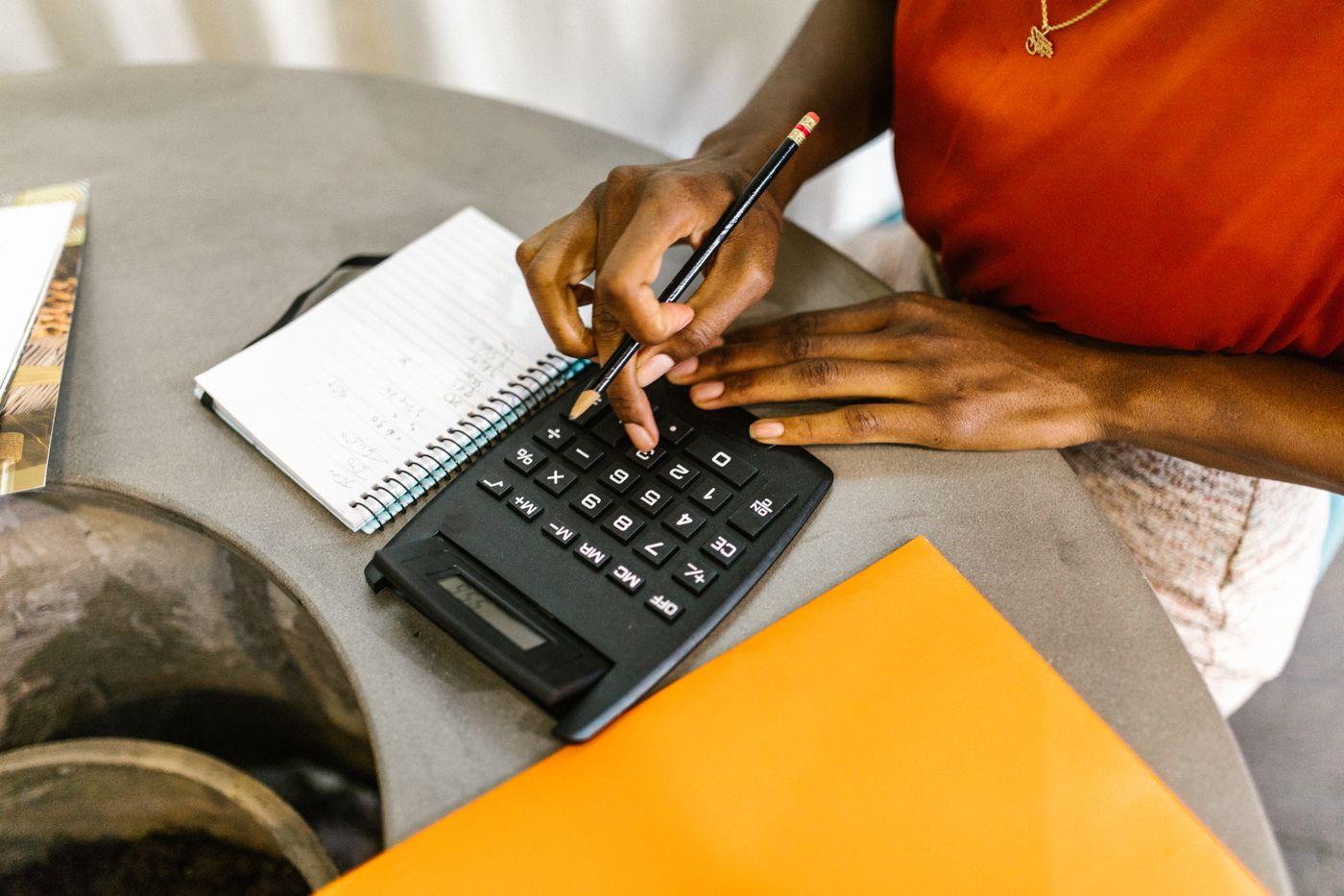 Financial planning with a calculator, handwritten notes, and colorful stationery